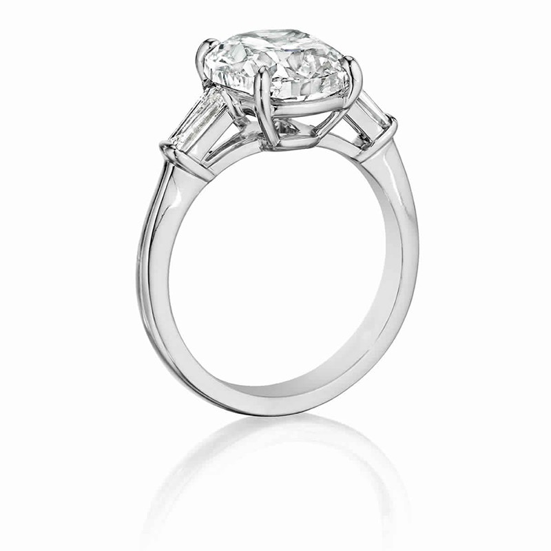 Henri Daussi engagement ring featuring a Signature Daussi Cushion cut accented by a tapered baguette on each side.  Set in 18kt white gold.