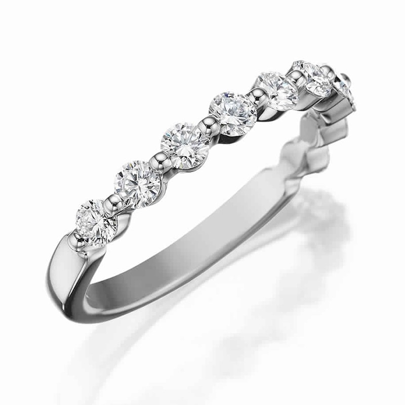 Henri Daussi white gold band featuring a shared prong single line of round brilliant white diamonds